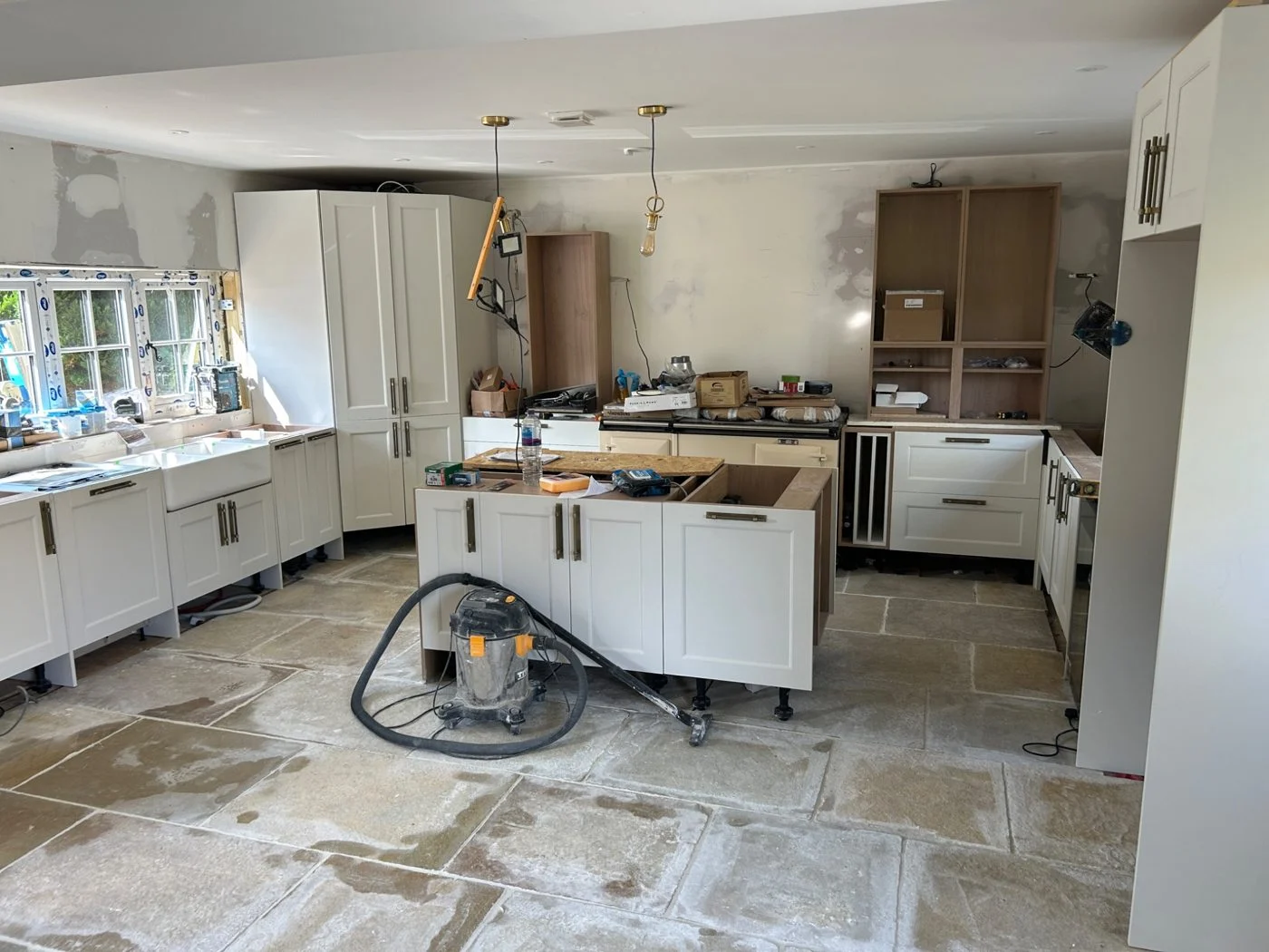 The same kitchen project during installation: cabinetry and flooring in place, with finishing work still to complete.