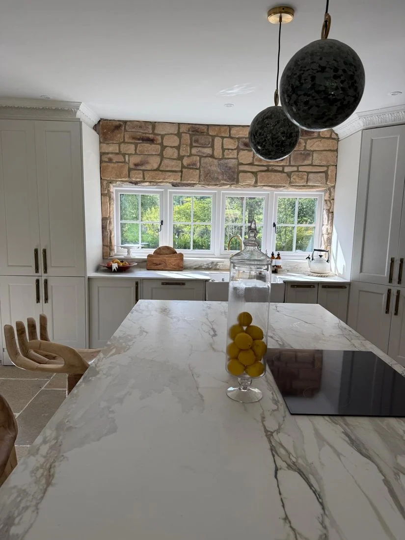 The completed kitchen: a stone feature wall, fitted cabinetry and a large island.